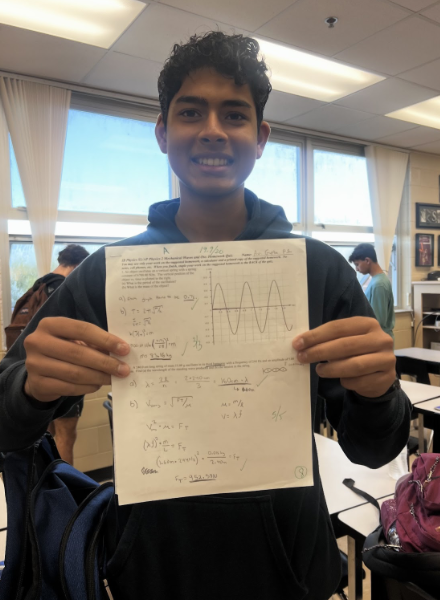 IB junior Avi Gupta holding up his math test.